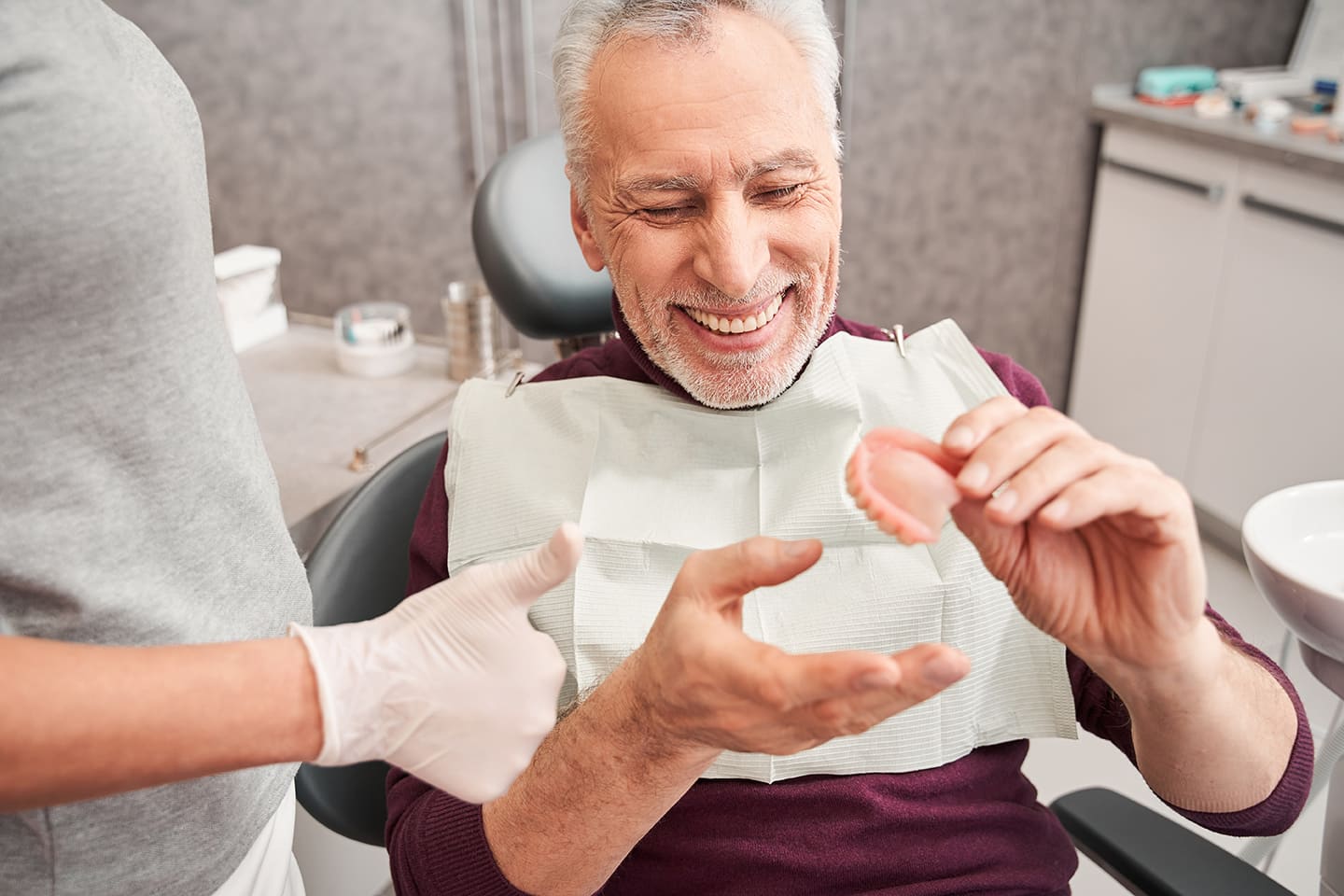 man holding dentures during denture consultation at smiles only in tucson arizona